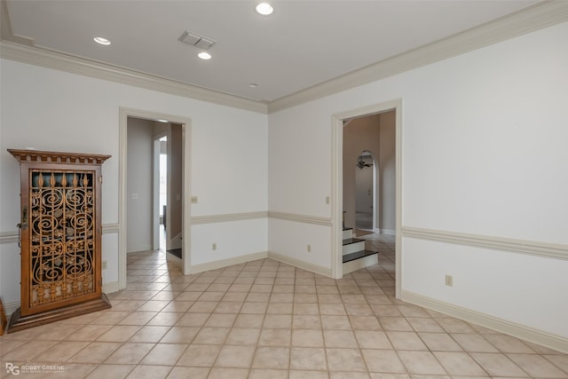 spare room featuring ornamental molding and light tile flooring