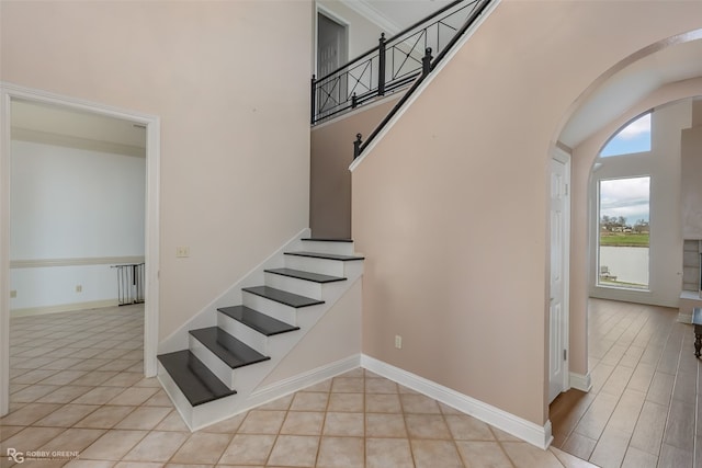 staircase with a high ceiling and light wood-type flooring