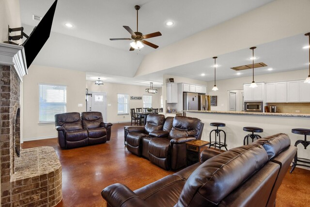 living room featuring lofted ceiling, ceiling fan, and a brick fireplace