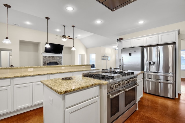 kitchen featuring stainless steel appliances, a brick fireplace, white cabinetry, lofted ceiling, and ceiling fan