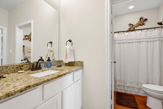 bathroom with a shower with shower curtain, toilet, and vanity