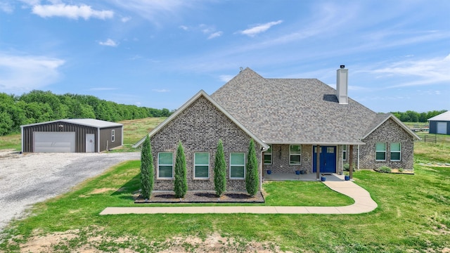 view of front of house with an outdoor structure, a garage, and a front yard