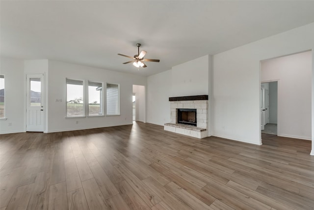 unfurnished living room featuring a fireplace, light wood-type flooring, and ceiling fan