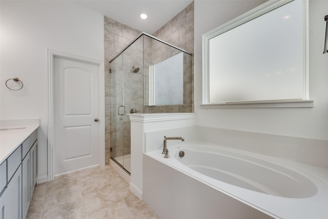 bathroom featuring vanity and independent shower and bath