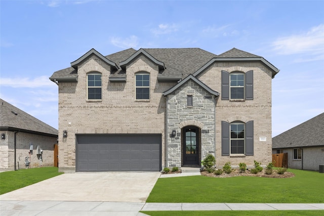 french country home featuring a front lawn and a garage