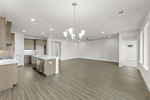 kitchen with dishwasher, an island with sink, hanging light fixtures, sink, and dark hardwood / wood-style flooring