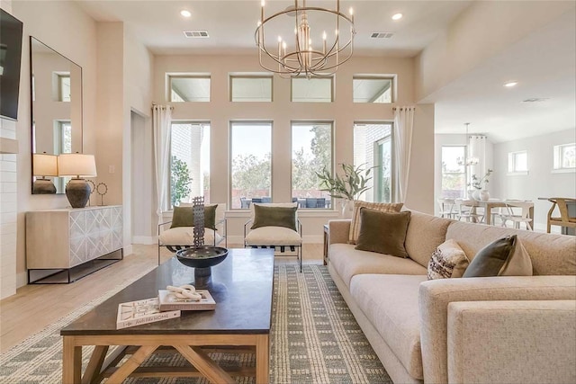 living room featuring a notable chandelier, hardwood / wood-style floors, and vaulted ceiling