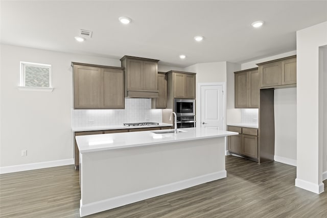 kitchen featuring sink, dark wood-type flooring, a kitchen island with sink, and stainless steel appliances