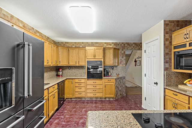 kitchen featuring black appliances, beverage cooler, light stone counters, a textured ceiling, and backsplash