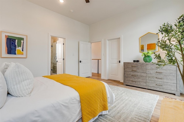 bedroom featuring light wood-type flooring, connected bathroom, and ceiling fan