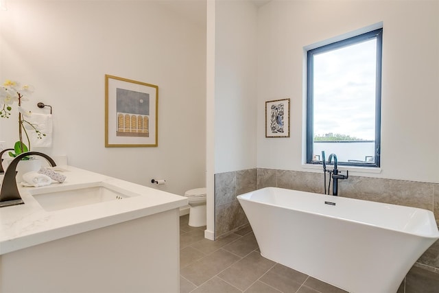 bathroom featuring vanity, toilet, a tub, and tile patterned flooring