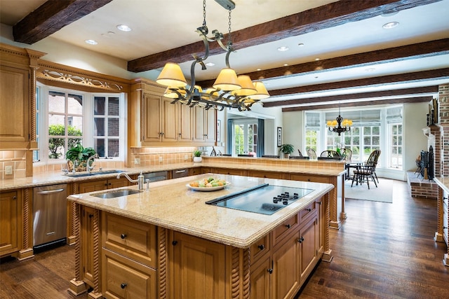 kitchen with a notable chandelier, hanging light fixtures, plenty of natural light, and an island with sink