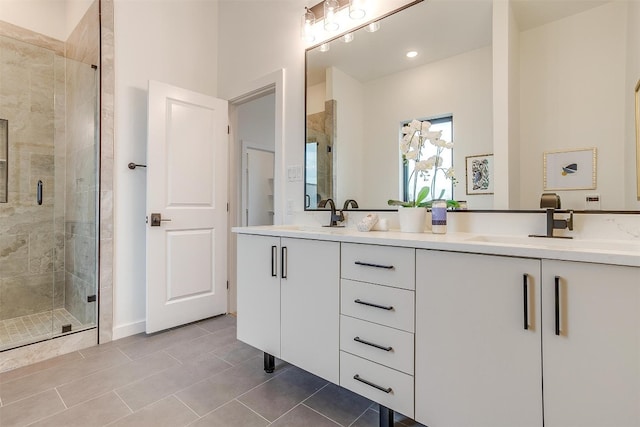 bathroom with tile patterned flooring, walk in shower, and vanity