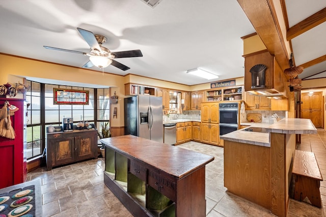 kitchen featuring tasteful backsplash, a peninsula, stone finish flooring, stainless steel appliances, and open shelves