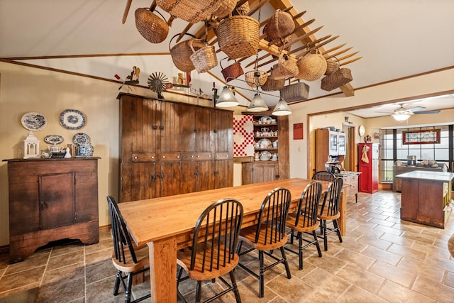 dining space with ornamental molding and stone finish flooring