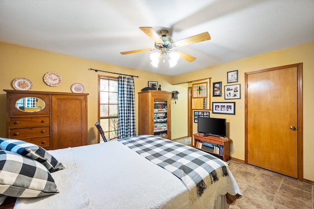 bedroom with a ceiling fan and baseboards