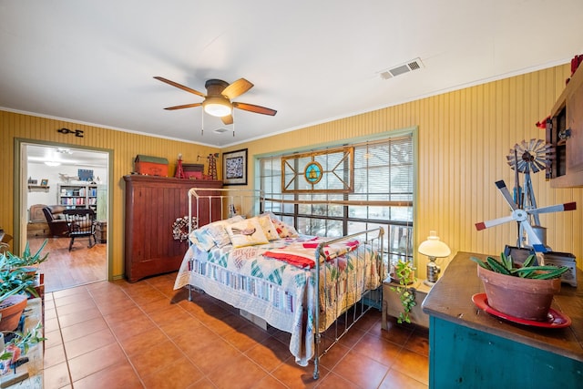 tiled bedroom featuring a ceiling fan, visible vents, and crown molding