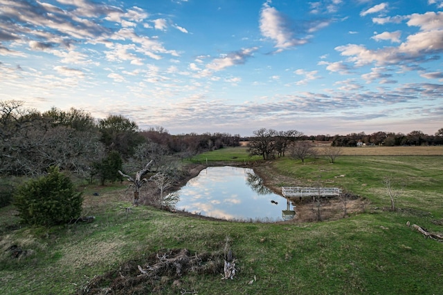 entry to storm shelter featuring a water view and a lawn