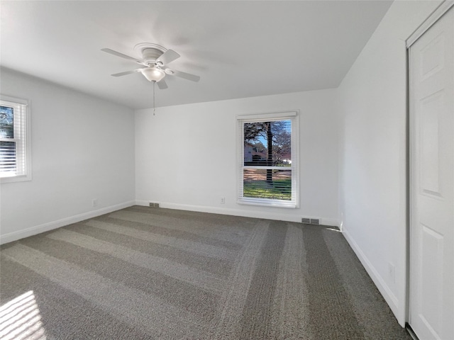 carpeted empty room featuring plenty of natural light and ceiling fan