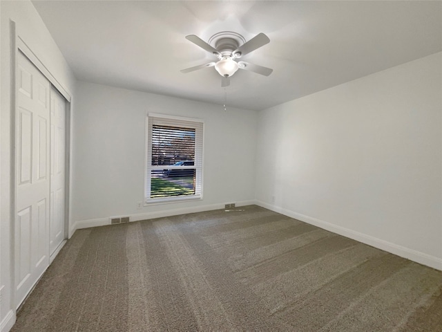 unfurnished bedroom with carpet floors, ceiling fan, and a closet