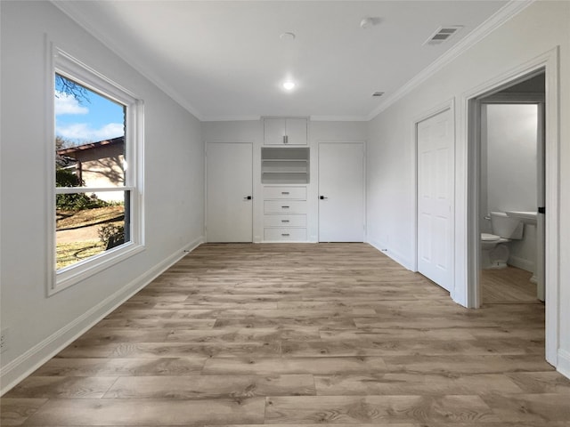 unfurnished bedroom featuring a closet, ensuite bath, light hardwood / wood-style flooring, and crown molding