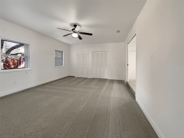 carpeted spare room with ceiling fan