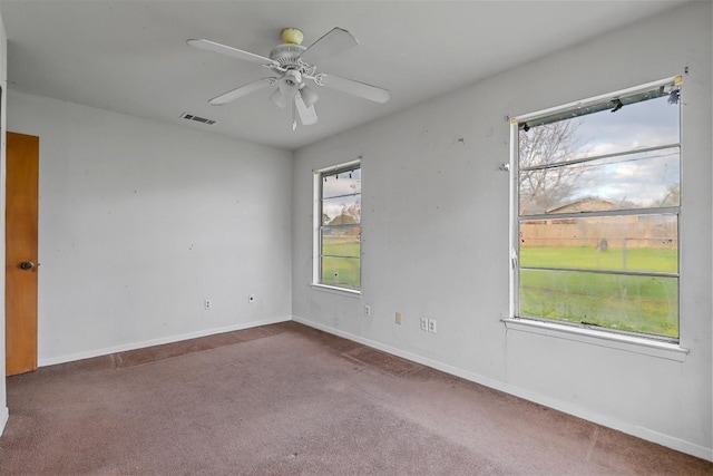 carpeted spare room featuring ceiling fan