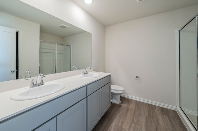 bathroom featuring vanity, hardwood / wood-style floors, an enclosed shower, and toilet