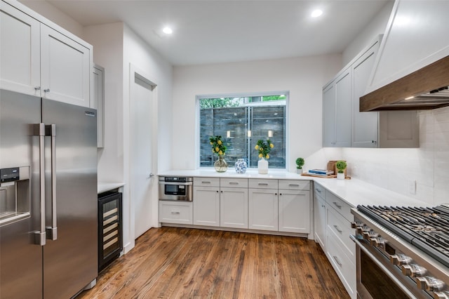 kitchen featuring beverage cooler, premium appliances, dark hardwood / wood-style floors, premium range hood, and white cabinets