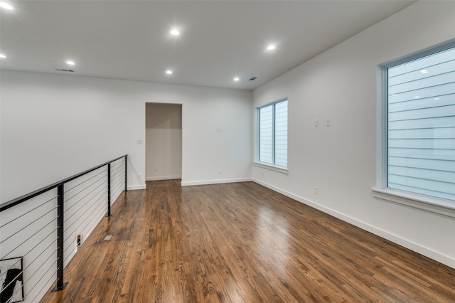 unfurnished room with dark wood-type flooring