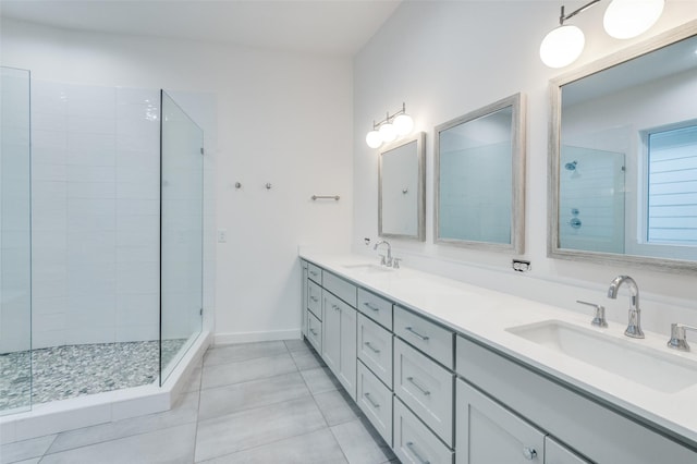 bathroom featuring tile patterned flooring, vanity, and a tile shower