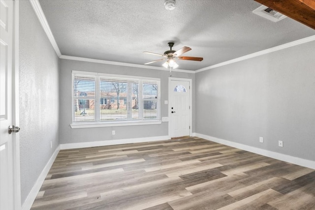 unfurnished room with a textured ceiling, crown molding, ceiling fan, and light wood-type flooring