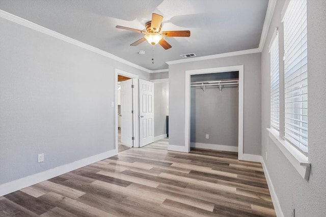 unfurnished bedroom with crown molding, a closet, ceiling fan, and light wood-type flooring