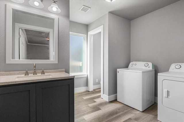 interior space featuring washer and dryer, light hardwood / wood-style floors, and sink