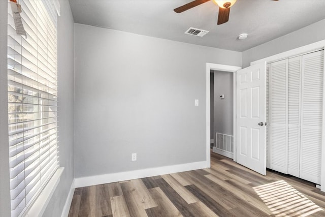 unfurnished bedroom with a closet, ceiling fan, and dark hardwood / wood-style floors