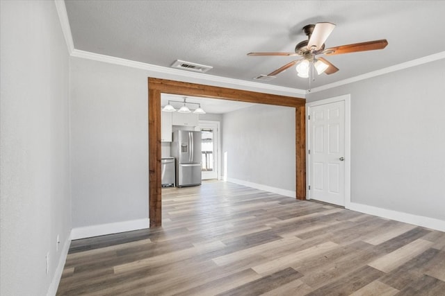 unfurnished room featuring crown molding, light hardwood / wood-style floors, a textured ceiling, and ceiling fan with notable chandelier