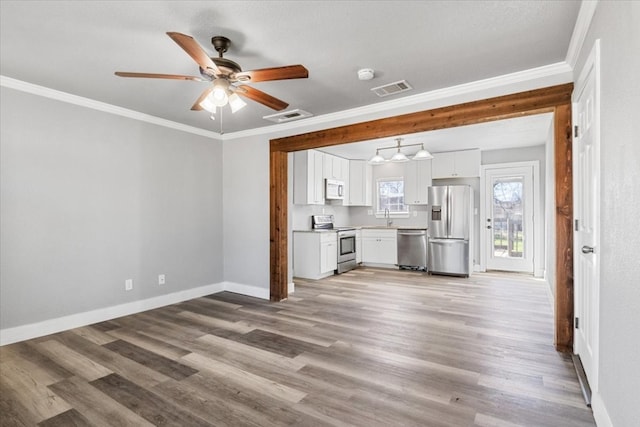 unfurnished living room featuring crown molding, light hardwood / wood-style floors, ceiling fan, and sink