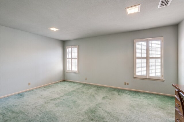 carpeted spare room with a textured ceiling