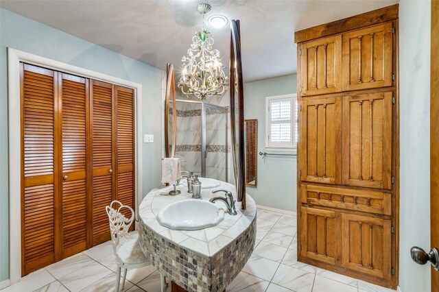 bathroom featuring tiled bath, tile floors, and sink