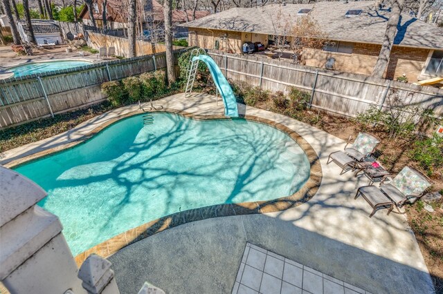 view of swimming pool featuring a water slide and a patio