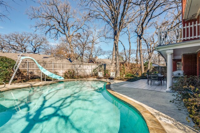 view of pool with a water slide and a patio area