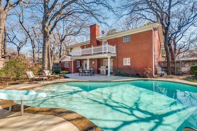 view of swimming pool featuring a patio, a grill, and a water slide