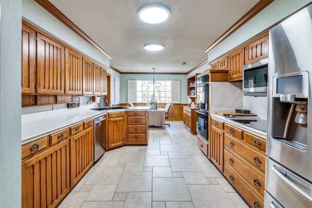 kitchen with light tile floors, kitchen peninsula, ornamental molding, appliances with stainless steel finishes, and hanging light fixtures