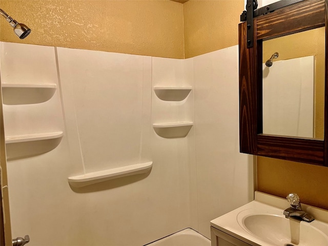 bathroom featuring a textured ceiling, vanity, and washtub / shower combination