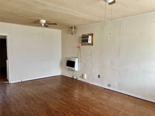 empty room featuring ceiling fan, a textured ceiling, dark hardwood / wood-style floors, and a wall unit AC