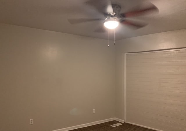 carpeted spare room with ceiling fan