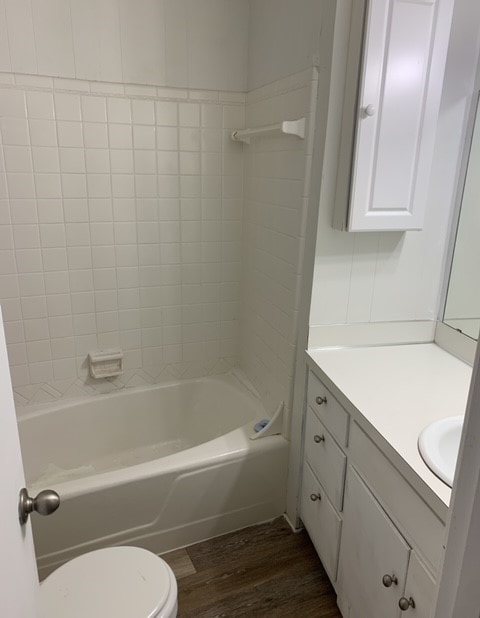 full bathroom featuring tiled shower / bath combo, oversized vanity, toilet, and wood-type flooring