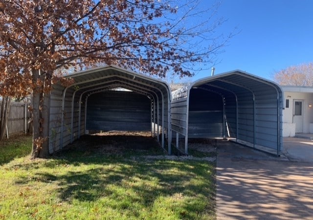 garage featuring a carport and a lawn