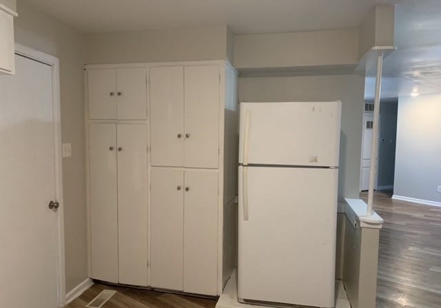 kitchen featuring white cabinetry, hardwood / wood-style flooring, and white refrigerator