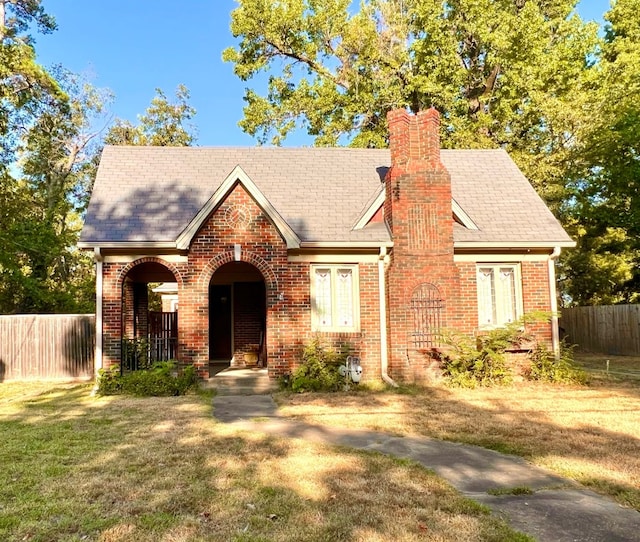 tudor home with a front lawn